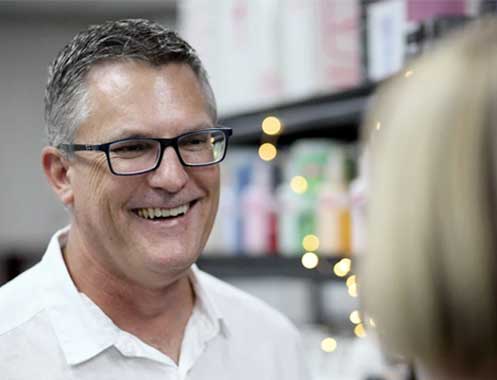 Ian in the KSHE showroom, laughing with a client in front of the retail shelving