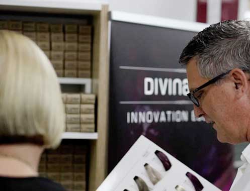 Ian showing a Divina colour swatch book to a client beside the colour wall