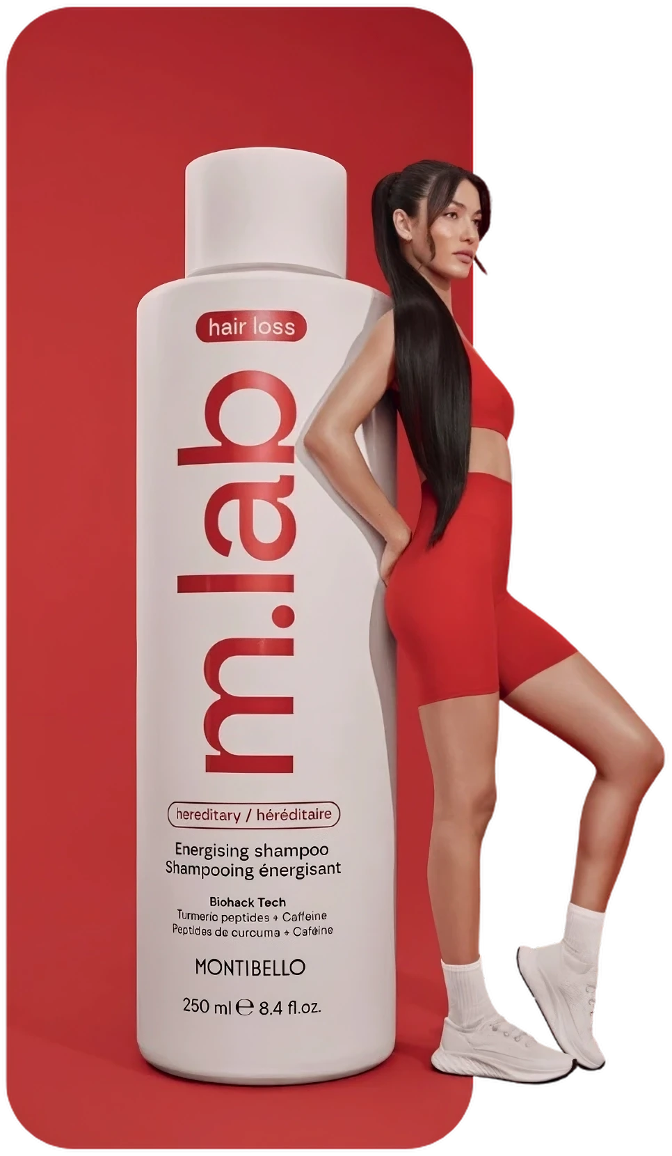 Woman in red athletic wear leans on a giant Montibello m.lab hair loss shampoo bottle.